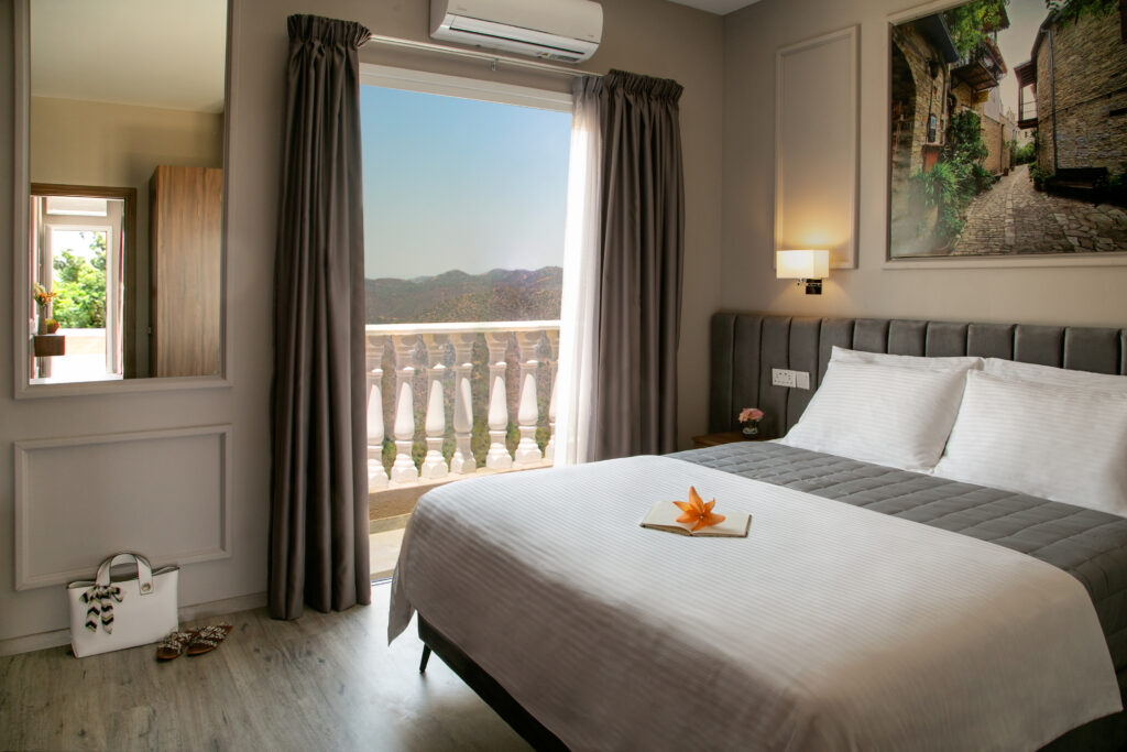 A bright bedroom with a balcony and mountain views at Archontiko Kiverniti in Pano Lefkara